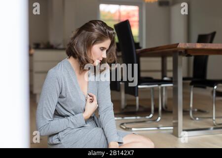 Junge Frau auf dem Boden im Speisesaal Stockfoto