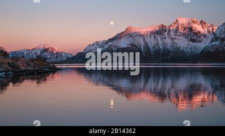 Bergspitzen im Abend Licht reflektieren Zusammen mit dem Vollmond im Wasser, Lofoten, Nordland, Norwegen Stockfoto