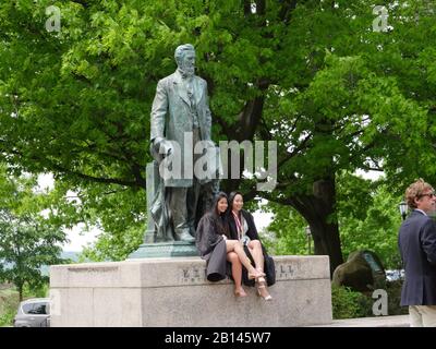 Cornell University, Ithaca, Graduierungstag, Studenten posieren mit Statue des Gründers Stockfoto