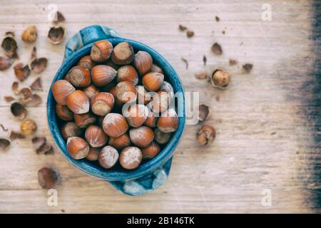 Corylus avellana. Haselnüsse in einer Schüssel auf einem Holzbrett Stockfoto