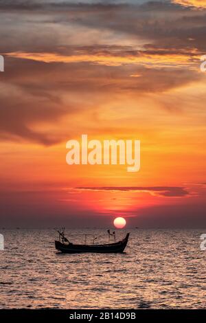 Fischerboot im Meer bei Sonnenuntergang Stockfoto