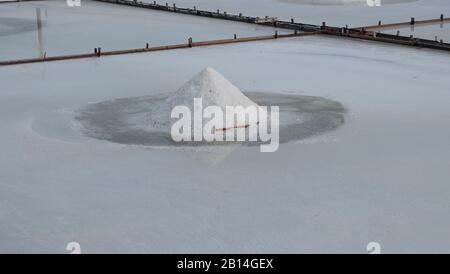 Weißes Salz sammelte sich in einem von weißem Salz umgebenen Haufen auf einem Salzfeld. Stockfoto