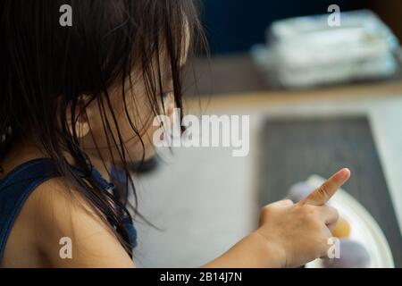 Asiatische Kleinkind Mädchen zeigen irgendwo. Rückansicht. Stockfoto