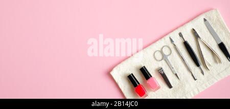 Maniküre und Pediküre auf pinkfarbenem Hintergrund. Draufsicht mit Kopierbereich. Designvorlage für Nagelsalon Banner. Konzept für Schönheitsbehandlungen Stockfoto