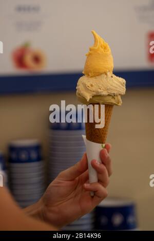 Hand mit Waffelkegel und Eiscreme darin, Restaurant berühmtes italienisches Gelato. Stockfoto