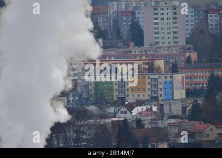 Weißer Rauch kommt aus dem Schornstein eines Kraftwerks, um im Winter Wärme für Häuser und Mehrfamilienhäuser zu erzeugen Stockfoto