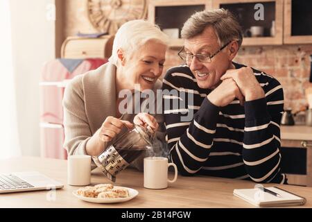 Romantisches älteres Paar, das Morgenkaffee in der Küche zusammen genießt Stockfoto