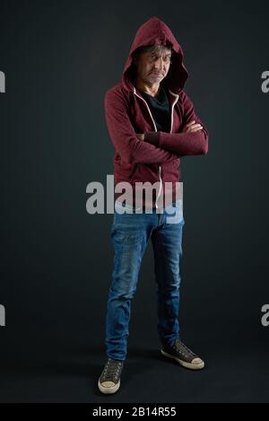 Porträt eines Mannes mit rotem Hemd und Denim-Hose auf verlaufenem Hintergrund Stockfoto