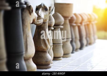 Lustiges Gesicht auf dem Ritter des Schachtes aus Holz. Mit einem kochigen Lächeln können Sie dem Ritter des Schachs gegenübertreten. Selektiver Fokus und warmer Lichteffekt Stockfoto