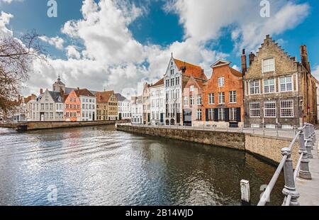 Alte bunte Steinhäuser in der Nähe des Kanals sind das Wahrzeichen von Brüggen, Belgien. Brügges Kanäle mit alten Steinbrücken sind eine berühmte Touristenattraktion. Stockfoto