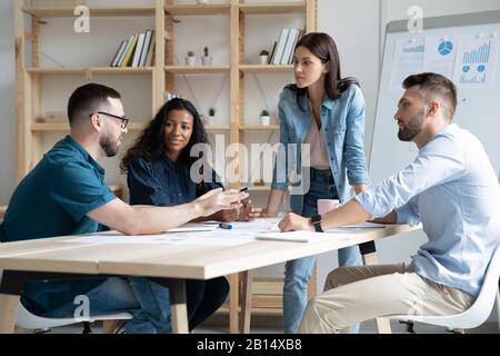 Fokussierte gemischte Rennen Unternehmen Mitarbeiter Unternehmen Mitarbeiter diskutieren Projekt. Stockfoto