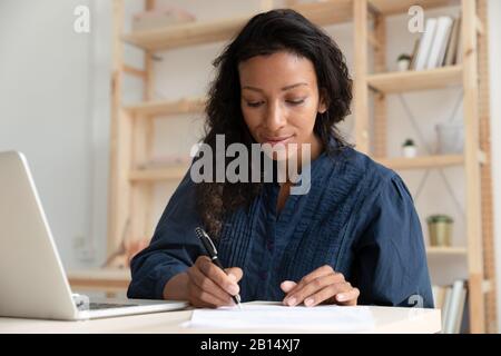 Konzentriertes professionelles Schreiben von Notizen während des Webinars. Stockfoto