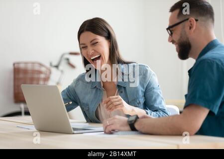 Überglücklich junge Kollegen, die auf den Computerbildschirm blicken. Stockfoto