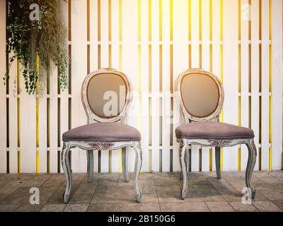 Retro Vintage Grunge Stuhl mit Kopierraum - zwei Retro-Vintage-Sessel mit weißem Holz-Pritschenhintergrund schmücken mit hängendem Zierplan Stockfoto