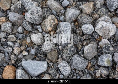 Steine aus Granit schließen Texturhintergrund. Glaziale raue natürliche graue Steine auf der Flussseite. Musterressourcen Stockfoto