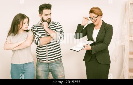 Immobilienmakler zeigt Skrupel Zustimmung zu jungen Paaren im offenen Haus Stockfoto