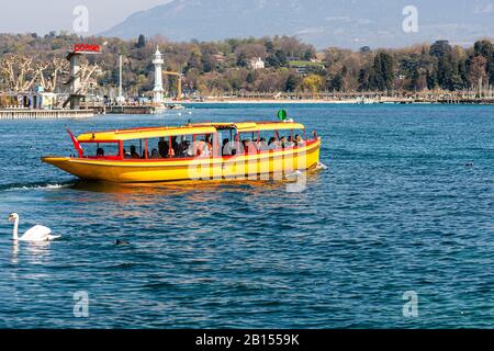 Genf, Schweiz - 14 April, 2019: Blick auf eine gelbe und rote Mouettes Genevoises Navigation Boot, eine öffentliche Verkehrsmittel Boot unterwegs über den See Stockfoto