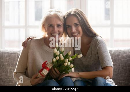 Glückliche Erwachsene Tochter, die Mutter mittleren Alters umarmte. Stockfoto