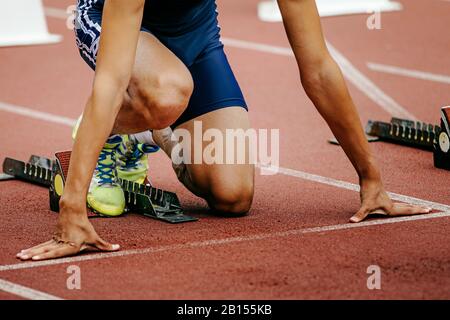 Man Athlet Runner auf der Startlinie sprinten aus Startblöcken Stockfoto