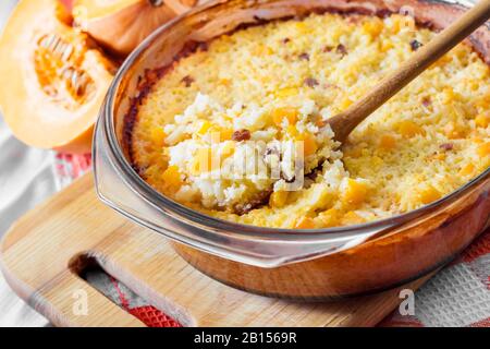 Gebackene süße milchige Hirse und Reisporridge mit Kürbis und Rosinen in Glaspanne Stockfoto