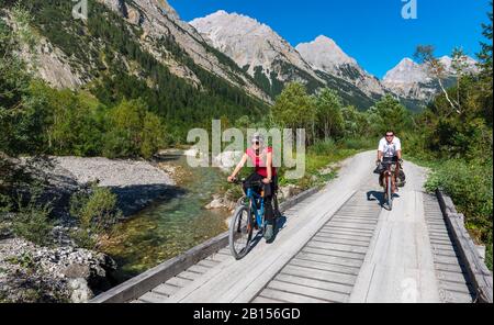 Radfahrer, Mountainbiker radeln auf Brücke über Bergbach, Schotterweg nach Karwendelhaus, Karwendeltal, Tyrol, Österreich Stockfoto