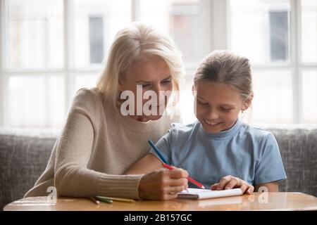 Fröhliche, reife Großmutter, die am Wochenende Zeit mit Enkelin verbringt. Stockfoto