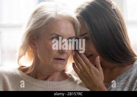 Schockierte Mutter mittleren Alters, die negative Nachrichten von Tochter hört. Stockfoto