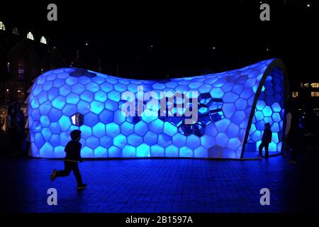 Ein kleines Kind läuft in Richtung Cellular Tessellation, einer Lichtskulptur von knapp, Nelson, Parsons 2014 Installation in VIVID Sydney. Stockfoto