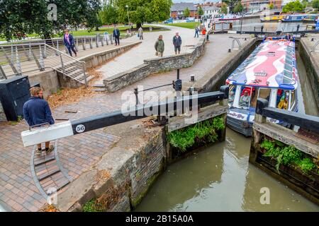 Ein farbenfrohes Langboot führt Touristen durch das Stratford upon Avon Canal Bassin, das sich auf den Fluss Avon, Warwickshire, England, Großbritannien erstreckt Stockfoto