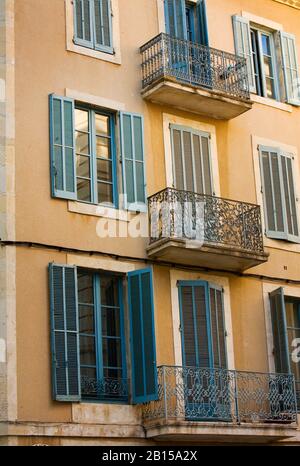 Fenster und dekorative Balkone an einem Haus in der Rue de la Violette, Nimes, Languedoc-Roussillon, Frankreich Stockfoto