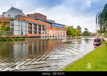 Ein buntes Vergnügungsboot führt Touristen am Royal Shakespeare Company Theatre am Fluss Avon, Stratford upon Avon, Warwickshire, England, Großbritannien vorbei Stockfoto