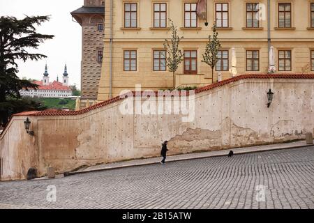 Prager Gebäude eine hohe Mauer unter dem Salmpalast mit Sgraffito; Reihen von Fenstern, Ke Hradu & Hradčanské nám. Mit dem Kloster Strahov im Hintergrund Stockfoto