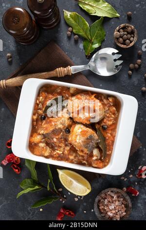 Seehechtfisch, in Tomatensauce mit Gemüse und Gewürzen gekocht Stockfoto