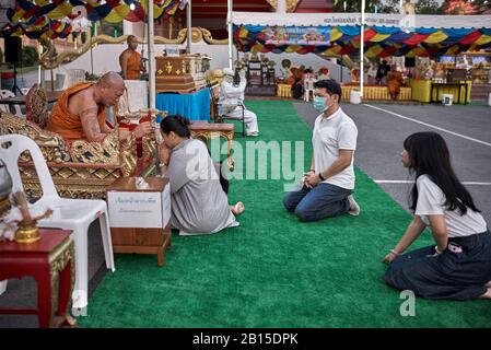 Thailands Familie von Mutter, Vater und Teenagertochter, die von einem Mönch Segen erhält. Stockfoto