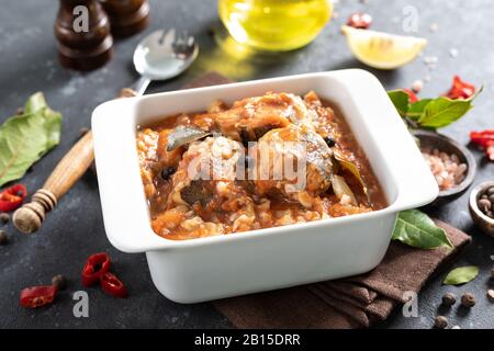 Seehechtfisch, in Tomatensauce mit Gemüse und Gewürzen gekocht Stockfoto
