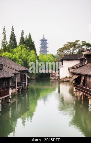 Die traditionelle chinesische Architektur säumte die Wasserkanäle mit der Bailischen Pagode im Hintergrund der Stadt Tongxiang Wuzhen, die in der Provinz Zhejiang liegt. Stockfoto