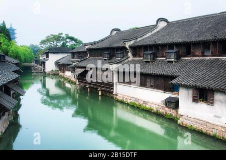 Gebäude und Brücken im chinesischen Stil über die Wasserkanäle in Tongxiang Wuzhens West Scenic Area in der Provinz Zhejiang in China. Stockfoto