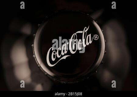 Krasnojarsk, Russland 23. Februar 2020: Coca-Cola-Logo, Korkkappe auf einer schwarzen Flasche Sekt, Draufsicht, Nahaufnahme. Illustrierende, dunkle Backgroun Stockfoto