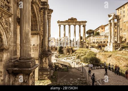 ROM, ITALIEN - 15. MAI 2014: Bogen von Kaiser Septimius Severus und Saturntempel in der Ferne auf dem Forum Romanum. Stockfoto
