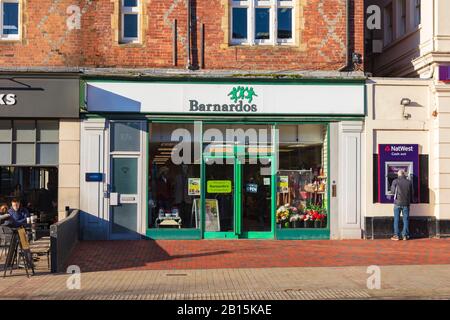 Barnardos Charity Shop an der Mount Pleasant Road, Tunbridge Wells, mit einem Geldautomat Nebenan, Kent, Großbritannien Stockfoto