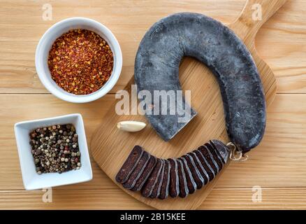 Schneiden Sie Scheiben der speziellen Pirot-Hufeisenwurst - Peglana Pirotska kobasica, aus Kalbfleisch, Schaf- und Ziegenfleisch, mit Zusatz von Knoblauch Stockfoto