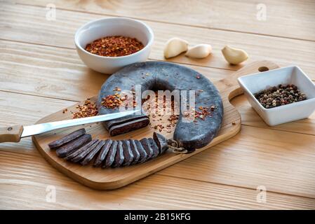 Schneiden Sie Scheiben der speziellen Pirot-Hufeisenwurst - Peglana Pirotska kobasica, aus Kalbfleisch, Schaf- und Ziegenfleisch, mit Zusatz von Knoblauch Stockfoto