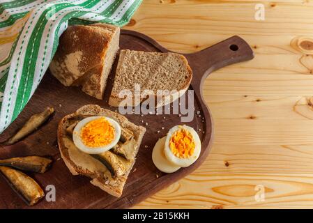 Skandinavisches Frühstück mit gekochtem Ei, kleinem Fisch und Roggenbrot. Zutaten für Sandwiches. Horizontal Stockfoto