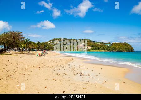 Bezaubernder Sandstrand an einem hellen sonnigen Tag mit azurblauem Himmel. Ein beliebter Urlaubsstrand mit Kreuzfahrtschiffen-Touristen Stockfoto