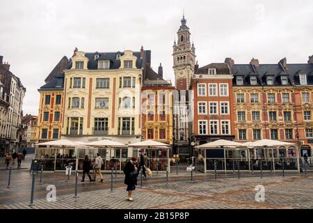 Selbst an einem regnerischen Tag verleihen atemberaubende Fassaden vom 17. Bis 20. Jahrhundert dem Hauptplatz von Lille Farbe. Eine alte Dame durchquert diesen 'Grand Place'. Stockfoto