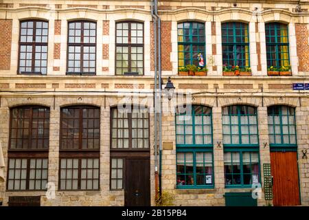 In der Altstadt von Lille stehen zwei symmetrische historische Häuser nebeneinander. Die hohen Fenster haben entweder grüne oder braune Muntine. Stockfoto