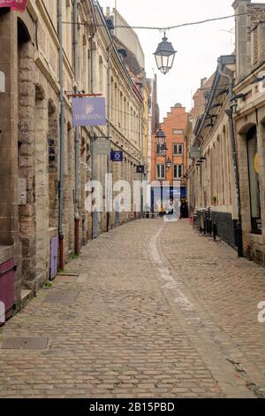 Eine leere Straße mit Kopfsteinpflaster führt zu einem flämischen Renaissancebau in der Altstadt von Lille. Stockfoto