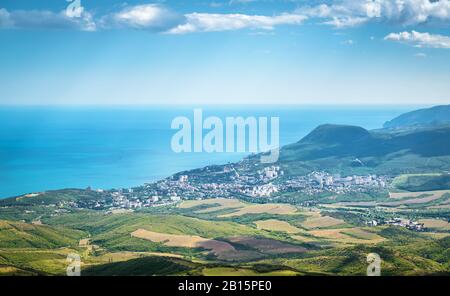 Luftbild mit Blick auf Alushta, Krim, Russland. Ferienort Alushta von oben im Sommer. Landschaft der Krim mit Küstenstadt. Panorama der Bla Stockfoto