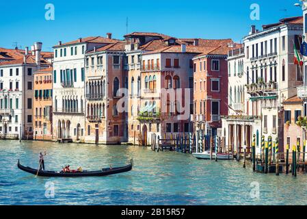 An einem sonnigen Tag segeln Gondeln mit Touristen am Canal Grande. Die Gondel ist der attraktivste Touristentransport Venedigs. Stockfoto