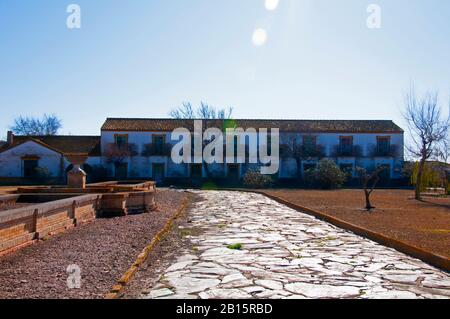 Die breite Straße mit Fliesen führt durch den verlassenen Park Sevilla, Spanien, zum großen weißen Haus Stockfoto